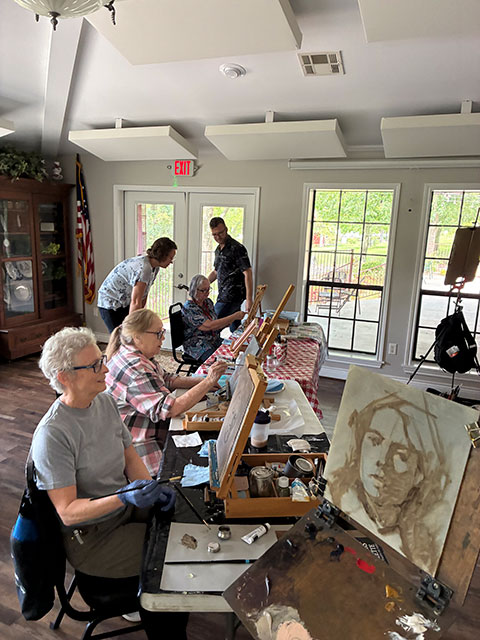 Photo of some of the members working on their paintings.